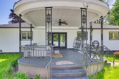 a covered porch of a white house with a ceiling at Game Room and Hot Tub! Cresco Family Home in Cresco