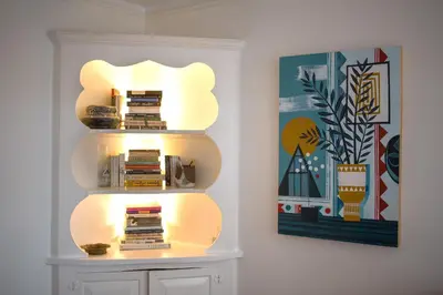 a book shelf with a light on it next to a painting at Garden Guest Suite in Brooklyn