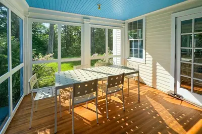 a screened in porch with a table and chairs at Close to Copake Lake! 4-Season Escape with Sauna in Copake Falls
