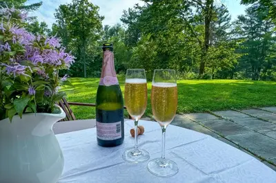 two glasses of champagne on a table with a bottle at Close to Copake Lake! 4-Season Escape with Sauna in Copake Falls