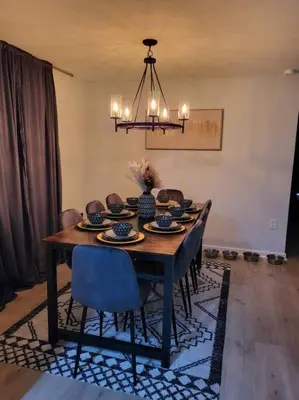 a dining room table with chairs and a chandelier at Lake Luxe in Lake Ariel