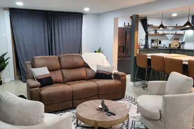 a living room with a couch and chairs and a kitchen at Lake Luxe in Lake Ariel