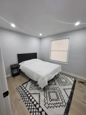 a white room with a bed and a rug at Lake Luxe in Lake Ariel