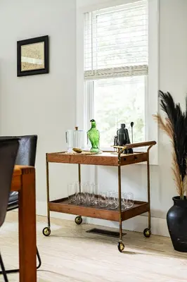 a serving cart with glasses on it in front of a window at Perch Eagle House - Creek Access, Sauna, Mt views in Boiceville