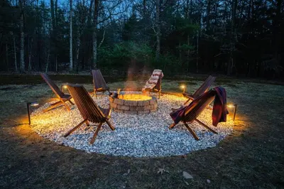 a group of chairs around a fire pit at night at Woodstock Retreat- Heated Pool/Hot Tub/FirePit in Saugerties