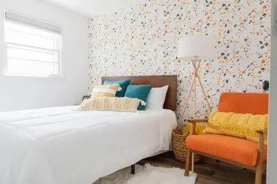 a bedroom with a bed and a chair at Retro Retreat: 1br home w/ WFH desk, livingroom, and fire pit in Kingston