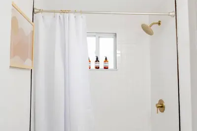 a shower with a white shower curtain in a bathroom at Retro Retreat: 1br home w/ WFH desk, livingroom, and fire pit in Kingston