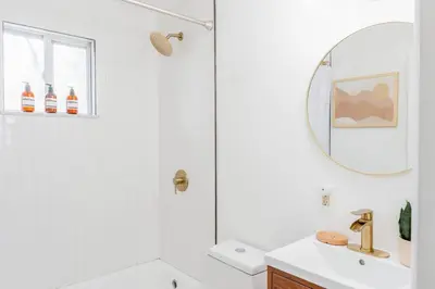 a white bathroom with a sink and a mirror at Retro Retreat: 1br home w/ WFH desk, livingroom, and fire pit in Kingston