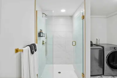 a shower with a glass door next to a washing machine at Hudson Valley and The Berkshires Getaway in Hillsdale