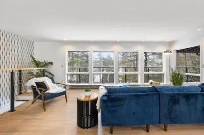 a living room with a blue couch and some windows at Hudson Valley and The Berkshires Getaway in Hillsdale
