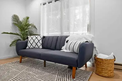 a blue couch in a living room with a window at Hudson Valley and The Berkshires Getaway in Hillsdale