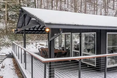 a cabin with a deck in the snow at Hudson Valley and The Berkshires Getaway in Hillsdale