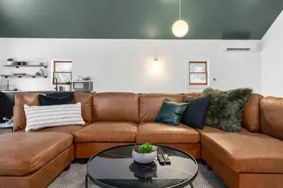 a living room with a brown couch and a table at Hudson Valley and The Berkshires Cottage in Hillsdale