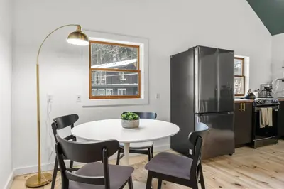 a kitchen with a white table and a black refrigerator at Hudson Valley and The Berkshires Cottage in Hillsdale