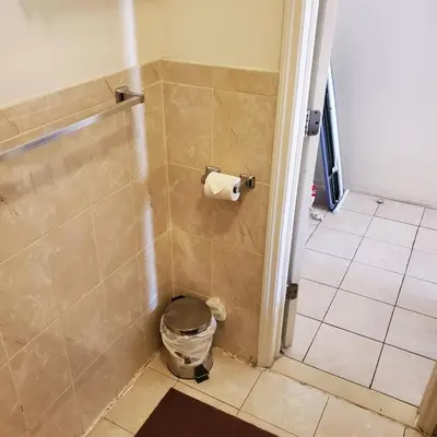 a bathroom with a shower with a toilet paper dispenser at New Studio apartments Available Now!! in Port Morris