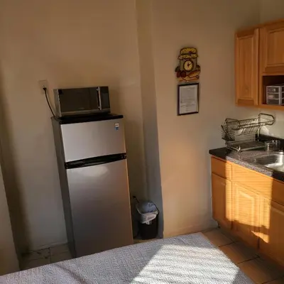 a kitchen with a microwave on top of a refrigerator at New Studio apartments Available Now!! in Port Morris