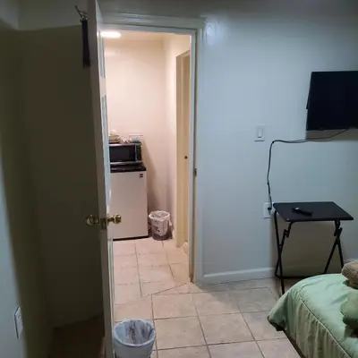 a bedroom with a door open to a room with a refrigerator at New Studio apartments Available Now!! in Port Morris