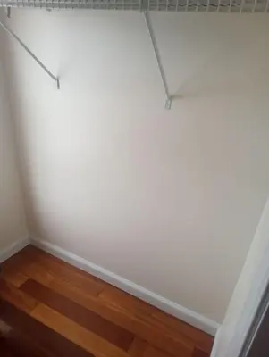 a room with white walls and a wooden floor at godlyone bedroom free parking in Schenectady