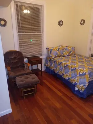 a bedroom with a bed and a chair at simple one bedroom free parking in Schenectady