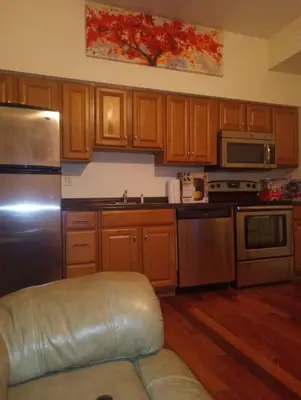 a kitchen with wooden cabinets and stainless steel appliances at simple one bedroom free parking in Schenectady