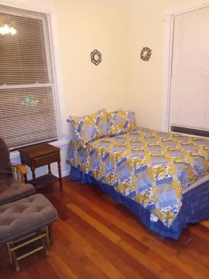 a bedroom with a bed and a chair at simple one bedroom free parking in Schenectady