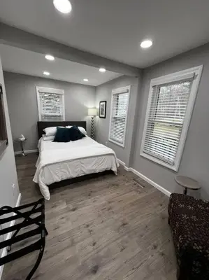 a bedroom with a bed and two windows and a couch at Esopus Creekside in Lake Katrine