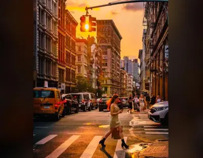 a woman crossing a busy city street with a traffic light at The Nolita Express Hostel in New York