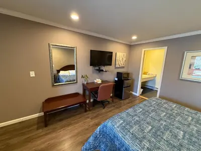 a bedroom with a bed and a desk and a television at Heidi's Inn in Brewster