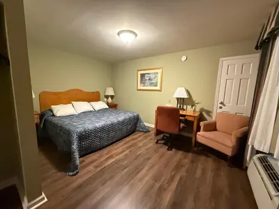 a bedroom with a bed and a desk and a chair at Heidi's Inn in Brewster