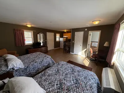 a bedroom with two beds and a living room at Heidi's Inn in Brewster