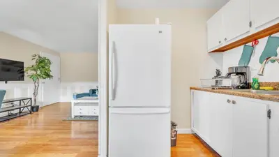 a white kitchen with a white refrigerator in a room at Central Chic Crib in Manchester
