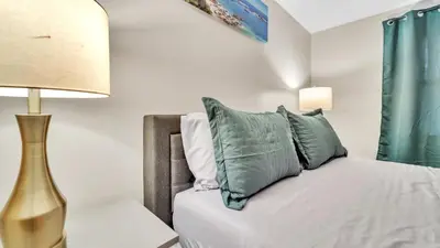 a bedroom with a bed with pillows and a lamp at Central Chic Crib in Manchester