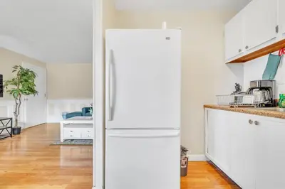 a white kitchen with a white refrigerator in a room at Central Chic Crib in Manchester