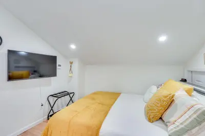 a bedroom with a bed with a tv on the wall at Dog-Friendly Fishkill Tiny House in Wine Country in Fishkill