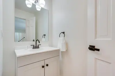 a white bathroom with a sink and a mirror at Dog-Friendly Fishkill Tiny House in Wine Country in Fishkill