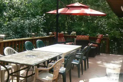 a table and chairs with an umbrella on a deck at Where Memories Are Made in West Kill