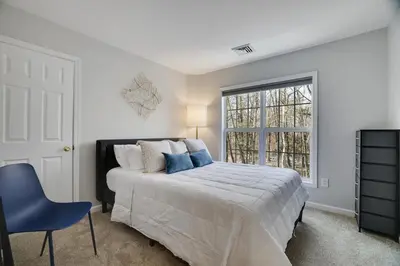 a white bedroom with a bed and a window at 30 Day Minimum Stay - Private Creekside Solace in East Stroudsburg