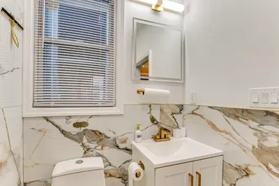 a bathroom with a sink and a toilet and a mirror at Jersey City Apartment with Game Room 7 Mi to NYC! in Jersey City
