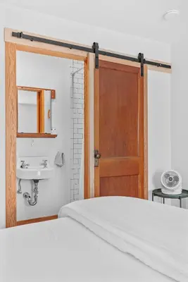 a bedroom with a bed and a sink and a door at Chambers Hollow in Walton