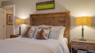 a bedroom with a large bed with two lamps at Secluded Estate • Optional Guest House Pond Playroom Gym Theater Sunny Pond by AvantStay in Austerlitz