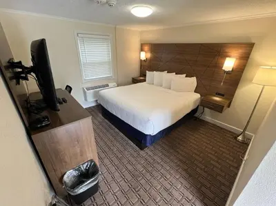 a hotel room with a bed and a television at River Valley Inn in Hatfield