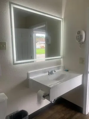 a bathroom with a sink and a mirror at River Valley Inn in Hatfield