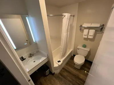 a bathroom with a sink and a toilet and a shower at River Valley Inn in Hatfield