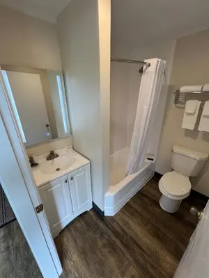 a bathroom with a toilet and a sink and a shower at River Valley Inn in Hatfield