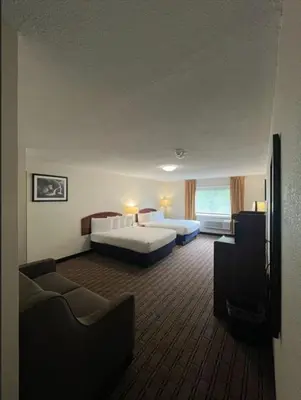a hotel room with two beds and a couch at River Valley Inn in Hatfield
