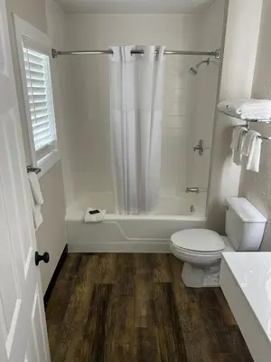 a white bathroom with a toilet and a shower at River Valley Inn in Hatfield