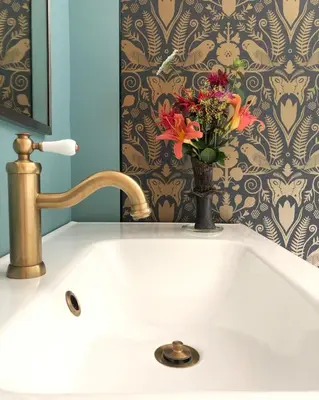 a bathroom sink with a vase of flowers on it at Serene Retreat on a Stream in Phoenicia