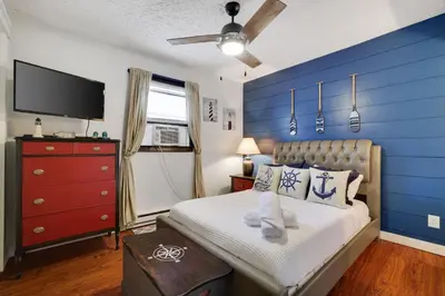 a bedroom with a blue accent wall and a bed at 2BR Cottage with Hot Tub in Tobyhanna