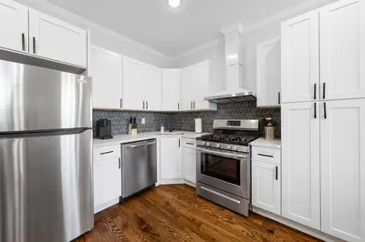 a kitchen with white cabinets and stainless steel appliances at Big City Living: Elegant Apartment with NYC Vibes in Jersey City