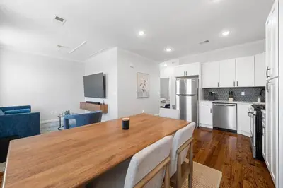a kitchen and dining room with a wooden table at Big City Living: Elegant Apartment with NYC Vibes in Jersey City